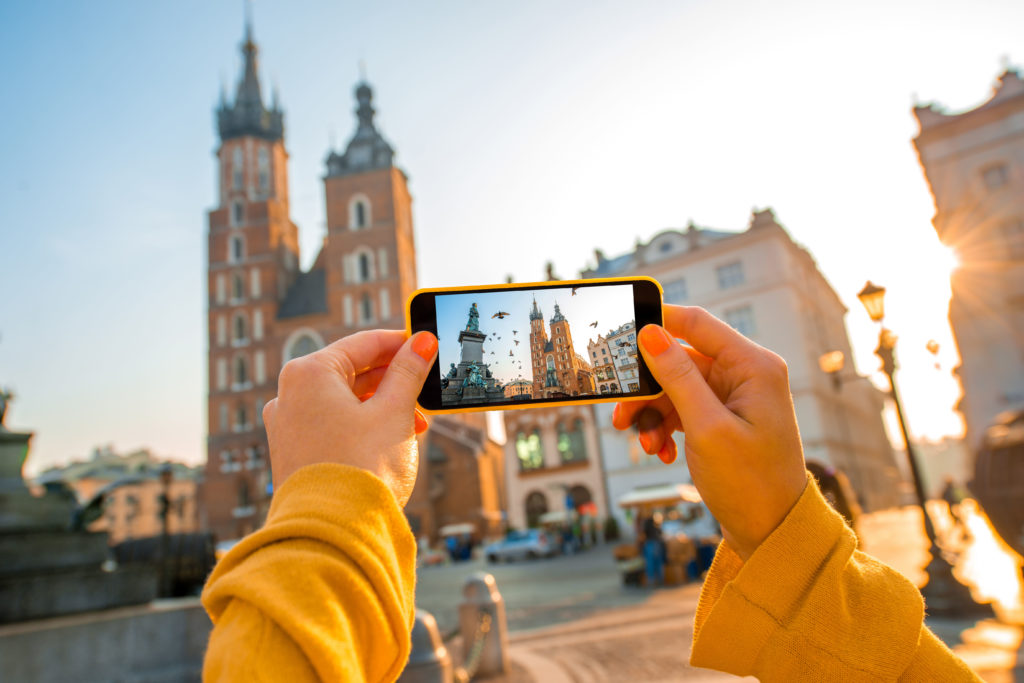 person holding phone up taking a picture travel agent ma